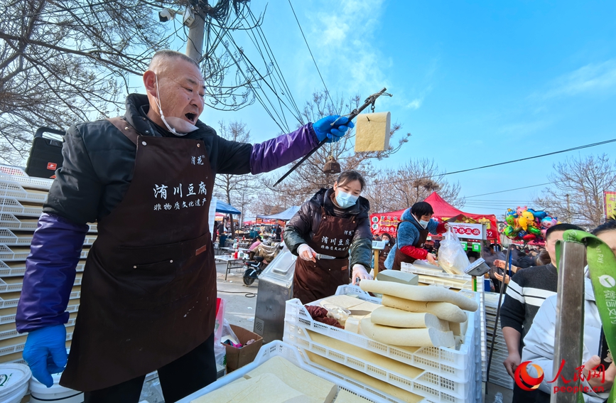 摊主向大家展示洧川豆腐的筋道。人民网记者 王佩摄