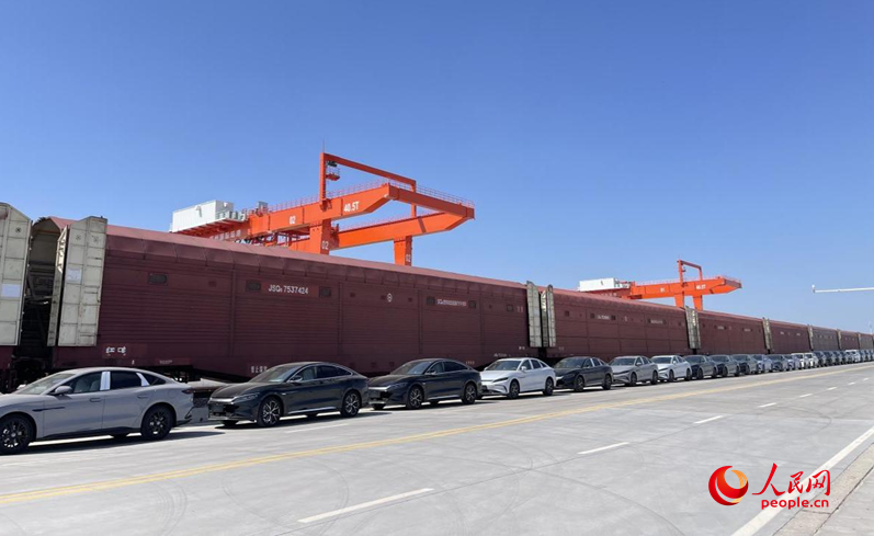 一辆辆“河南造”新能源汽车从郑州国际陆港出发。人民网 杨晓娜摄